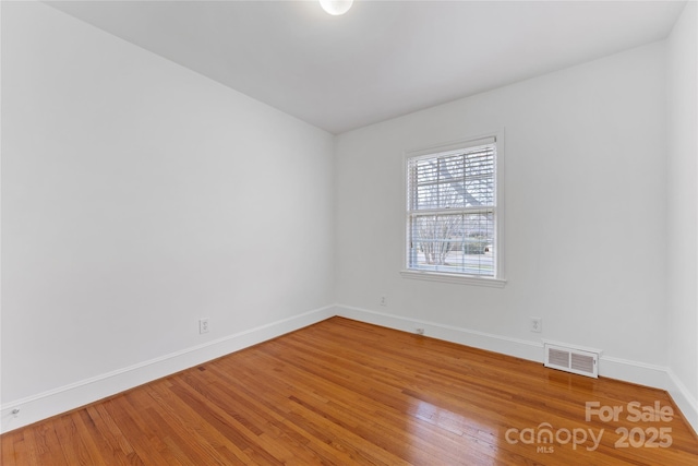 spare room with wood-type flooring