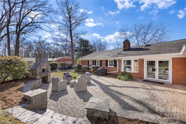 view of patio with french doors and an outdoor living space with a fireplace