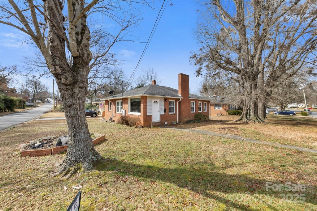 901 Maple Ave, Salisbury, NC 28144 - view of side of property featuring brick siding, a yard, and a chimney