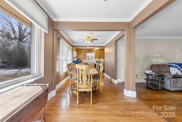 dining area featuring light wood-type flooring, ornamental molding, and plenty of natural light