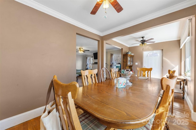 dining area with ceiling fan, crown molding, baseboards, and wood finished floors