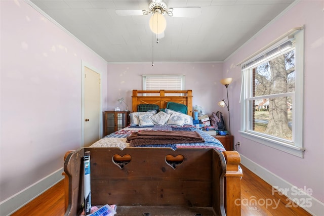 bedroom with ornamental molding, wood finished floors, and baseboards