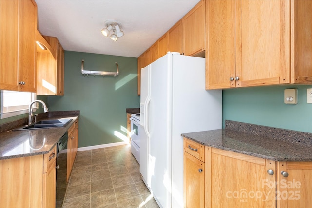 kitchen featuring sink, white appliances, and dark stone counters