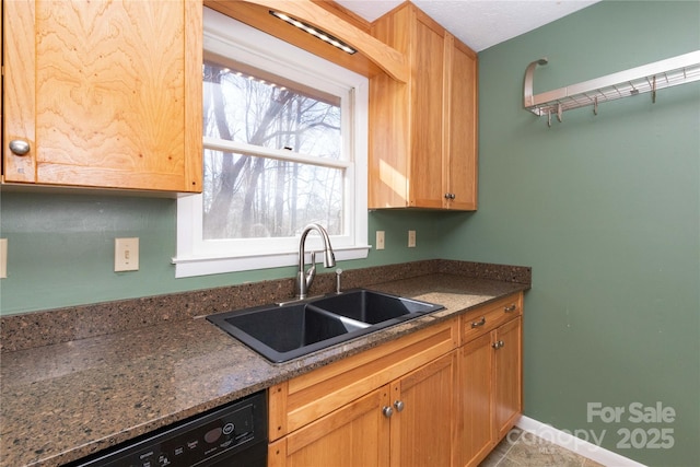 kitchen featuring black dishwasher, sink, and dark stone countertops