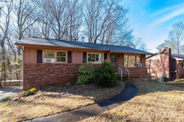 ranch-style house with central AC, a front lawn, and cooling unit