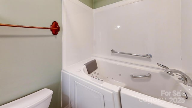 bathroom with a washtub and toilet