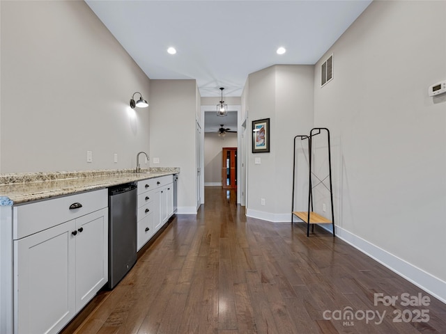 kitchen with sink, dishwasher, white cabinetry, and light stone countertops