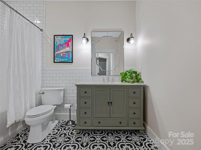 bathroom featuring tile walls, toilet, vanity, and tile patterned flooring