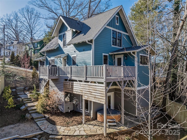 back of house featuring a deck and a hot tub