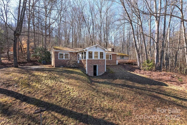 view of front of home with a sunroom and a front lawn