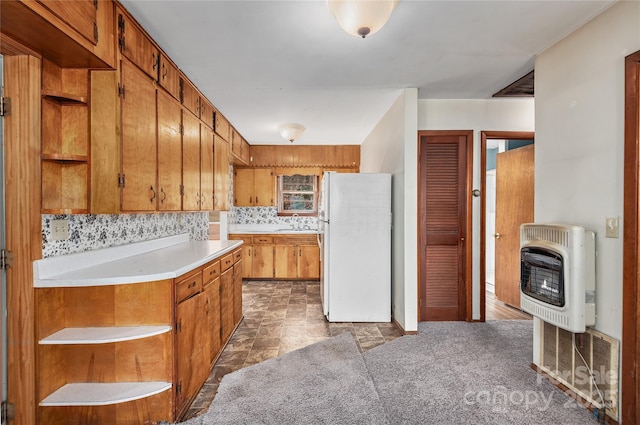 kitchen with white refrigerator, sink, heating unit, and backsplash