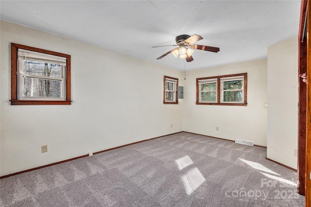 spare room featuring carpet, a healthy amount of sunlight, and ceiling fan