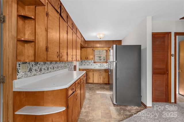 kitchen featuring stainless steel refrigerator, sink, and decorative backsplash