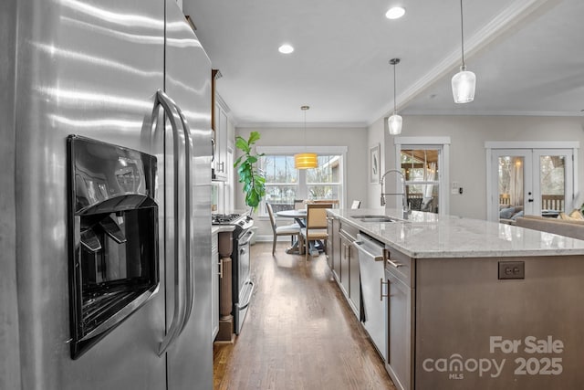 kitchen featuring pendant lighting, stainless steel appliances, french doors, sink, and ornamental molding