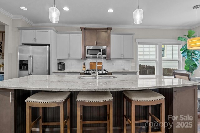 kitchen featuring crown molding, pendant lighting, a spacious island, decorative backsplash, and stainless steel appliances