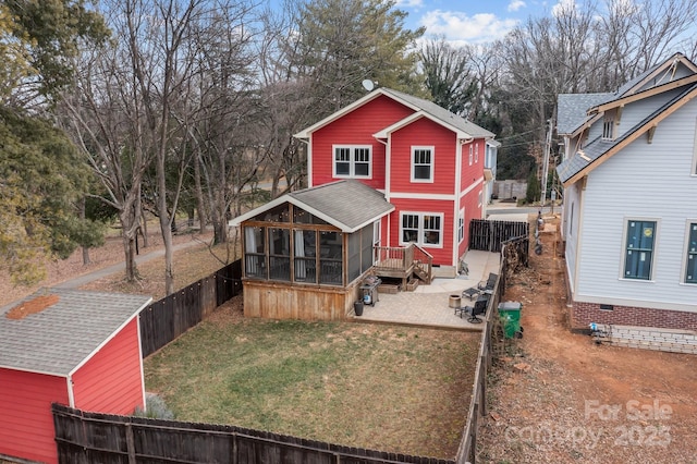 rear view of house with a patio area, a yard, and a sunroom