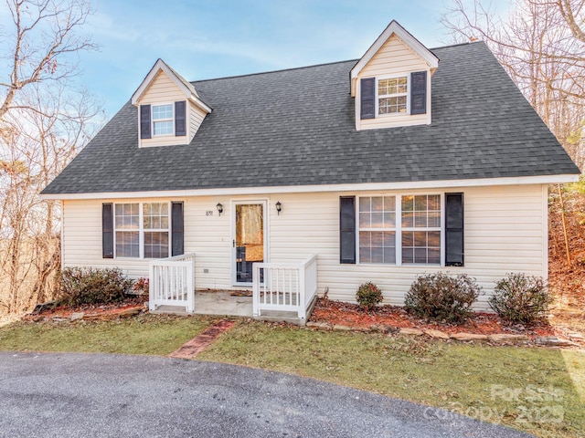 cape cod house featuring a front lawn