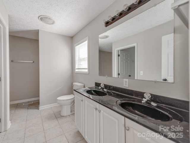 bathroom with vanity, a textured ceiling, tile patterned floors, and toilet