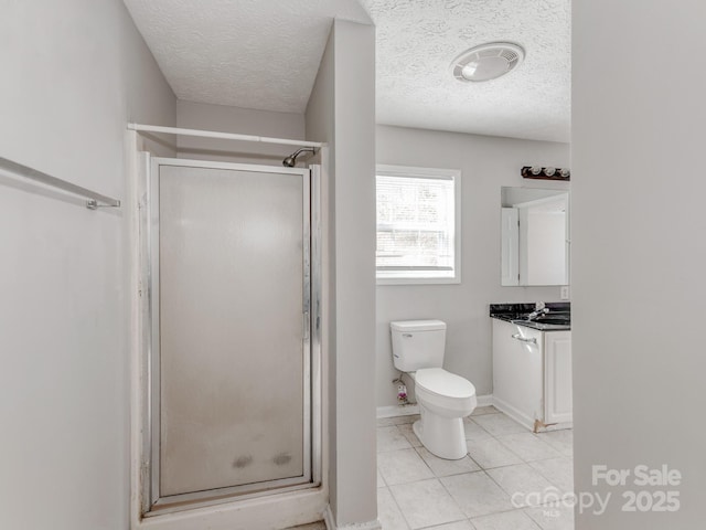 bathroom with tile patterned floors, toilet, a shower with shower door, and vanity