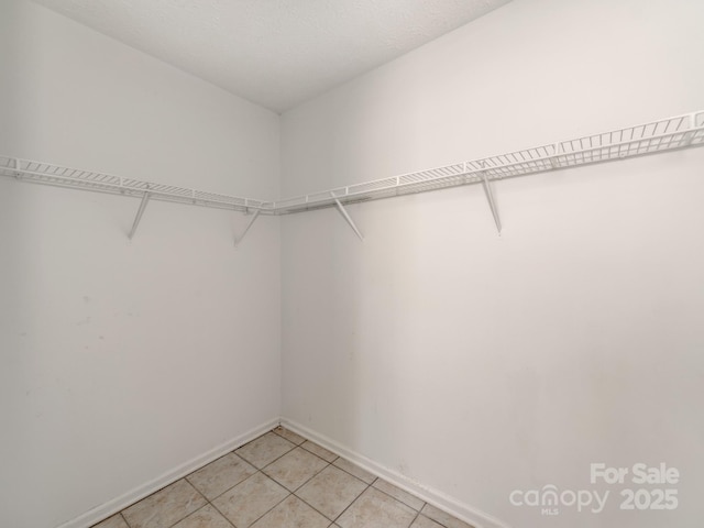 spacious closet with light tile patterned floors