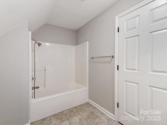 bathroom featuring a textured ceiling and  shower combination