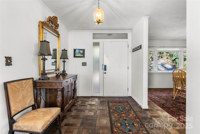 foyer featuring ornamental molding and baseboards