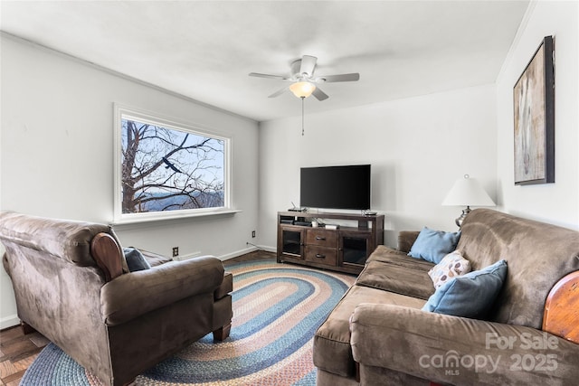 living area with a ceiling fan and baseboards