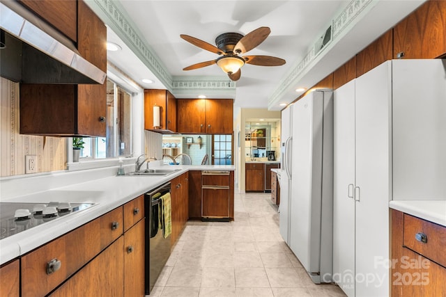 kitchen featuring white fridge with ice dispenser, brown cabinetry, light countertops, and a sink