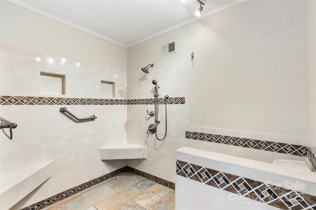 bathroom with tile walls, visible vents, crown molding, and tiled shower