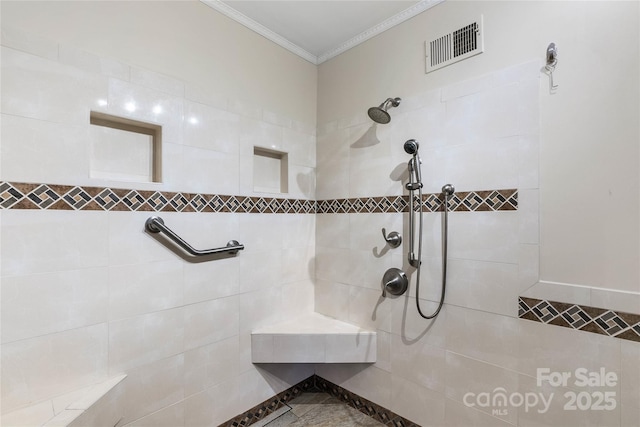 bathroom with tiled shower, crown molding, and visible vents