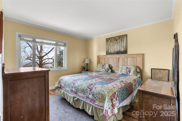 bedroom featuring baseboards, crown molding, and wood finished floors