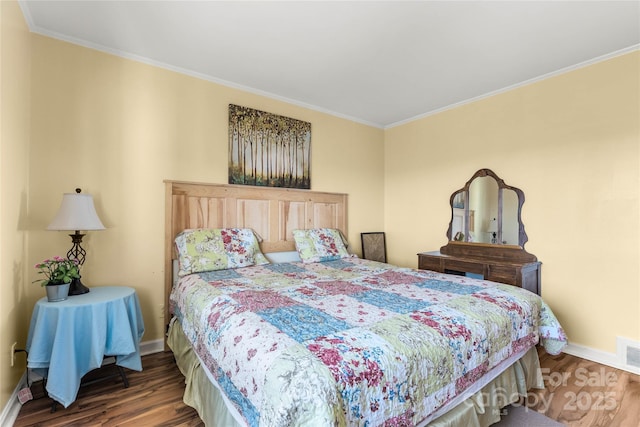 bedroom featuring dark wood-type flooring, crown molding, and baseboards