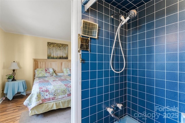 bedroom with ornamental molding, wood finished floors, and baseboards