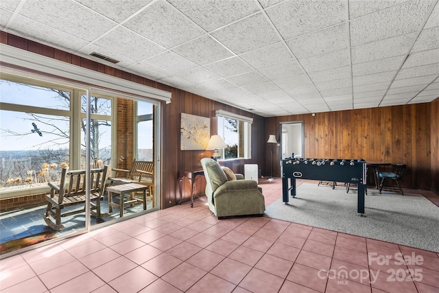 playroom with visible vents, wood walls, and tile patterned floors