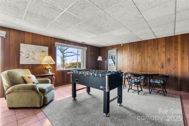 game room with wooden walls and tile patterned floors