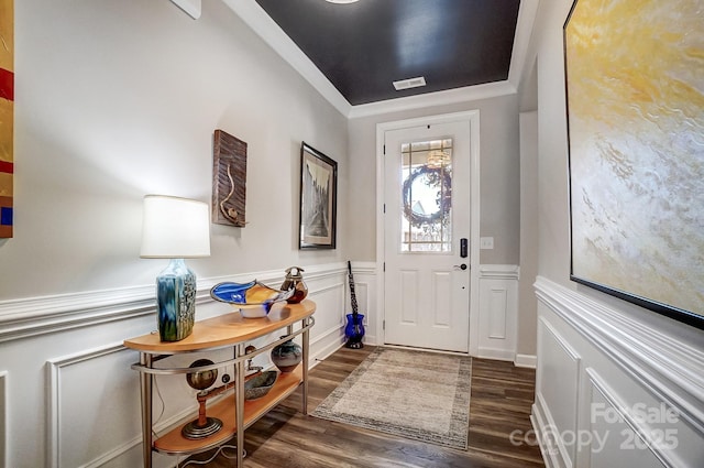 foyer with a wainscoted wall, dark wood-style floors, and a decorative wall