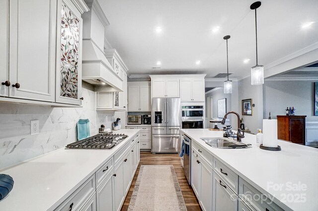 kitchen featuring ornamental molding, a sink, stainless steel appliances, light countertops, and custom exhaust hood