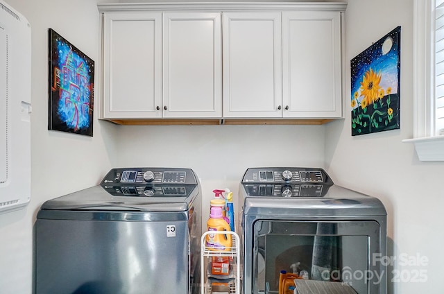 clothes washing area featuring washer and dryer and cabinet space