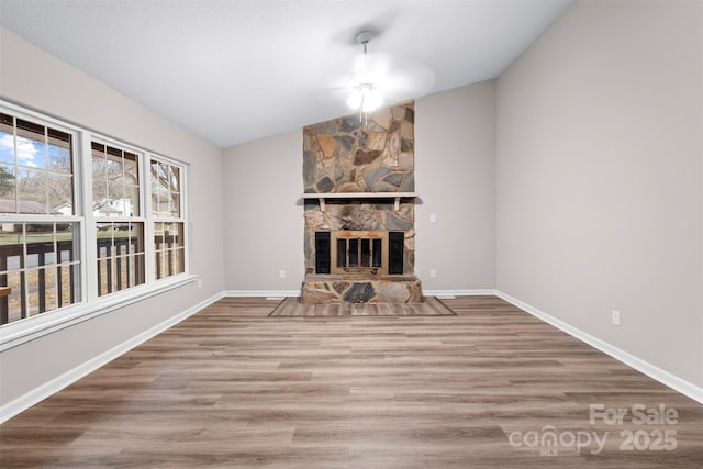 unfurnished living room with wood-type flooring, lofted ceiling, and a fireplace