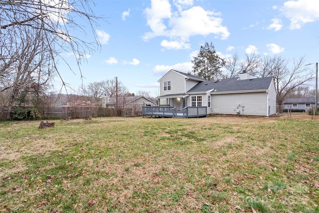 back of house featuring a lawn and a deck