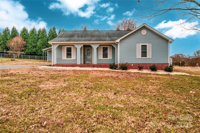 ranch-style home featuring covered porch and a front yard