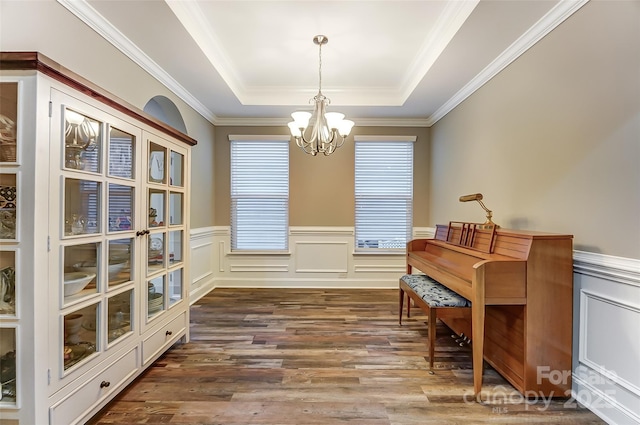 sitting room with crown molding, a tray ceiling, dark hardwood / wood-style floors, and a chandelier