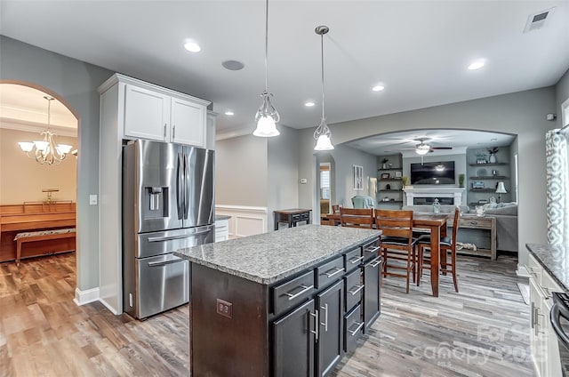 kitchen with a kitchen island, decorative light fixtures, white cabinetry, ceiling fan, and stainless steel refrigerator with ice dispenser