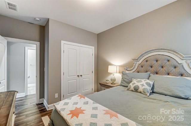 bedroom with dark wood-type flooring and a closet