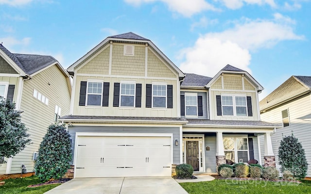 craftsman house featuring a garage, a porch, and a front lawn