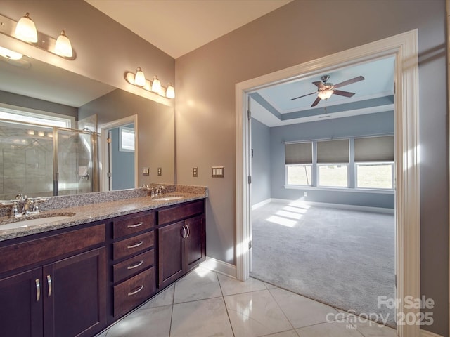 bathroom featuring tile patterned flooring, vanity, an enclosed shower, ceiling fan, and a raised ceiling