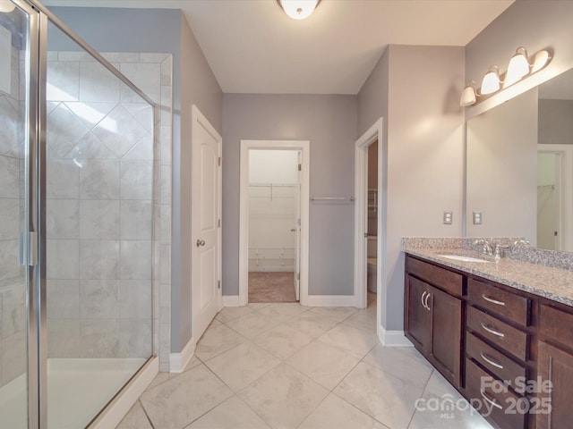 bathroom featuring vanity, tile patterned flooring, a shower with shower door, and toilet