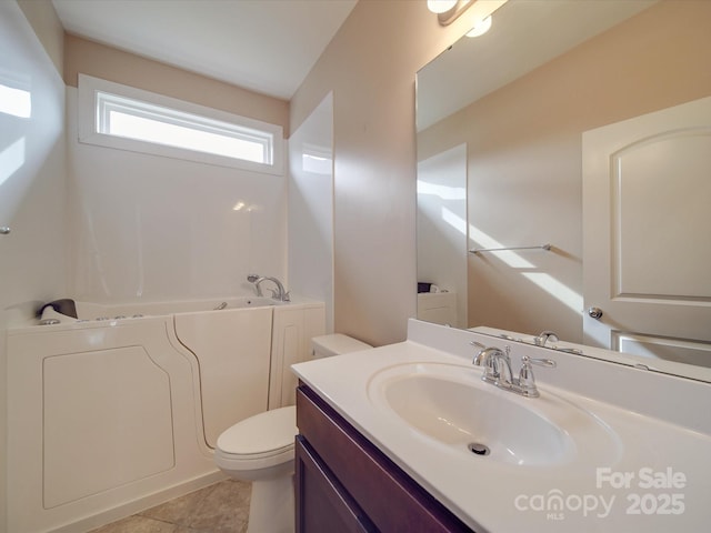 bathroom featuring vanity, toilet, a bathing tub, and tile patterned flooring