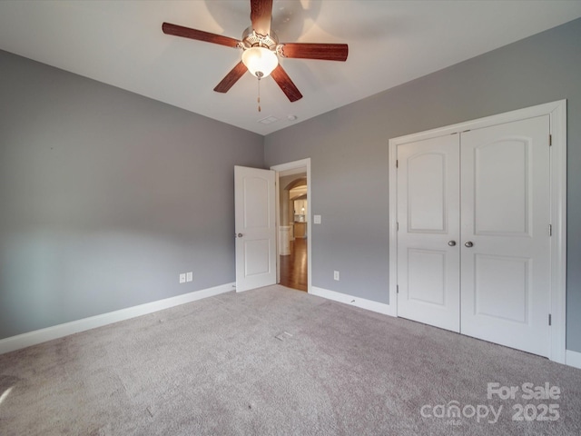 unfurnished bedroom with a closet, ceiling fan, and carpet