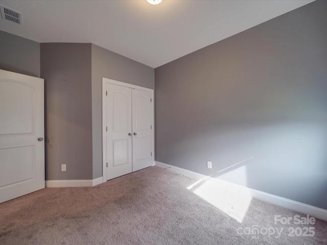 unfurnished bedroom with carpet floors and a closet